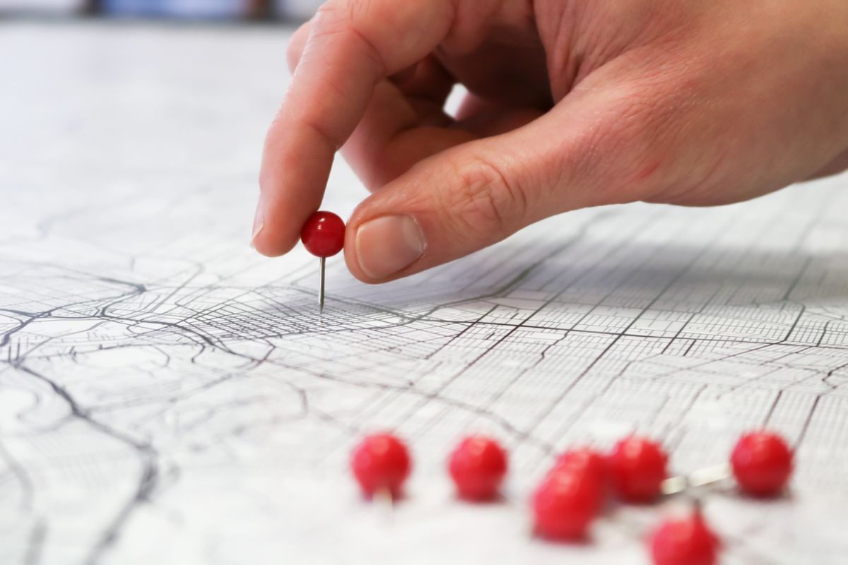 pessoa marcando localidades da telefonia brasileira em um mapa 