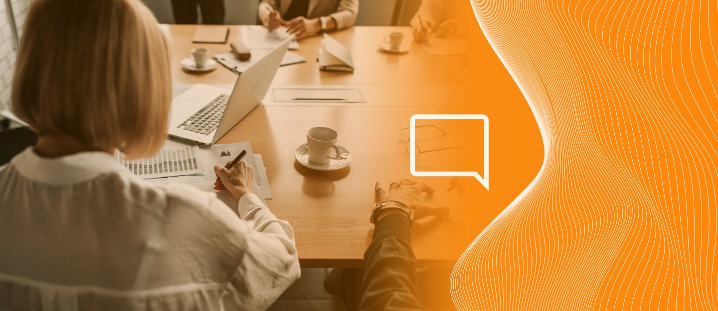 Pessoas em uma empresa sentados a mesa discutindo Qual PABX escolher: PABX Virtual ou PABX Tradicional?